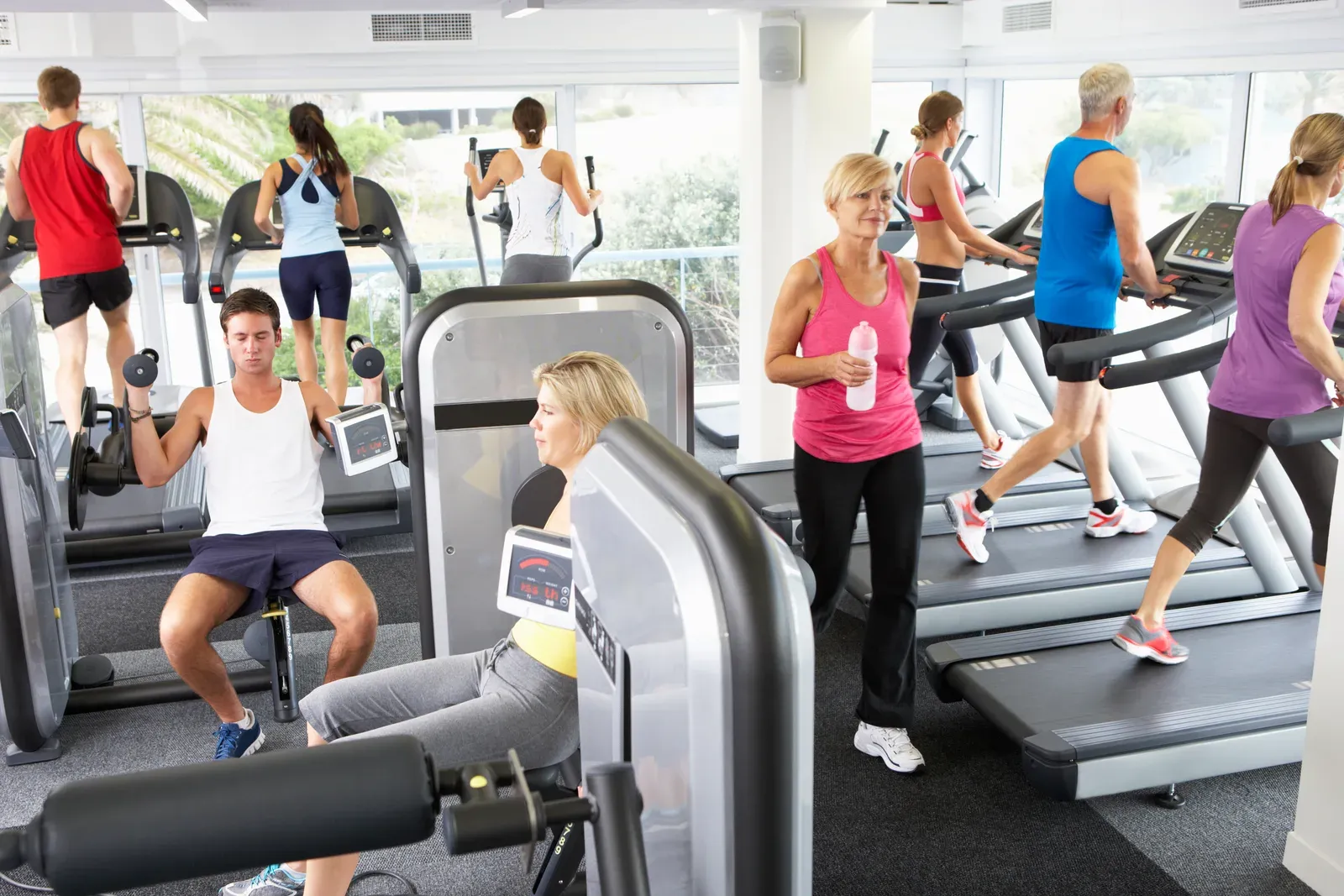 Crowded gym floor seen from above with people busy on machines