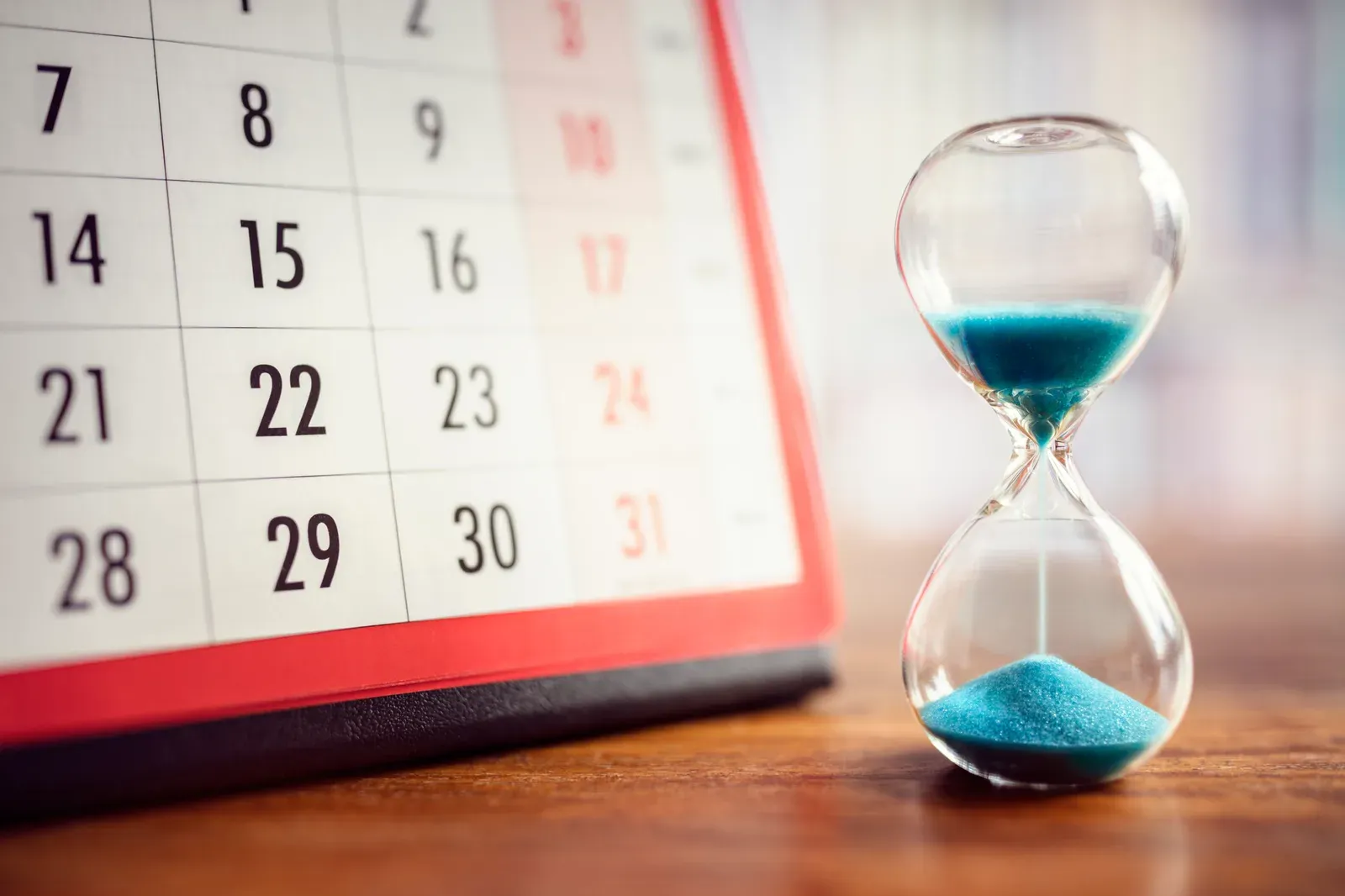 Hourglass beside a calendar, counting down to an event training deadline