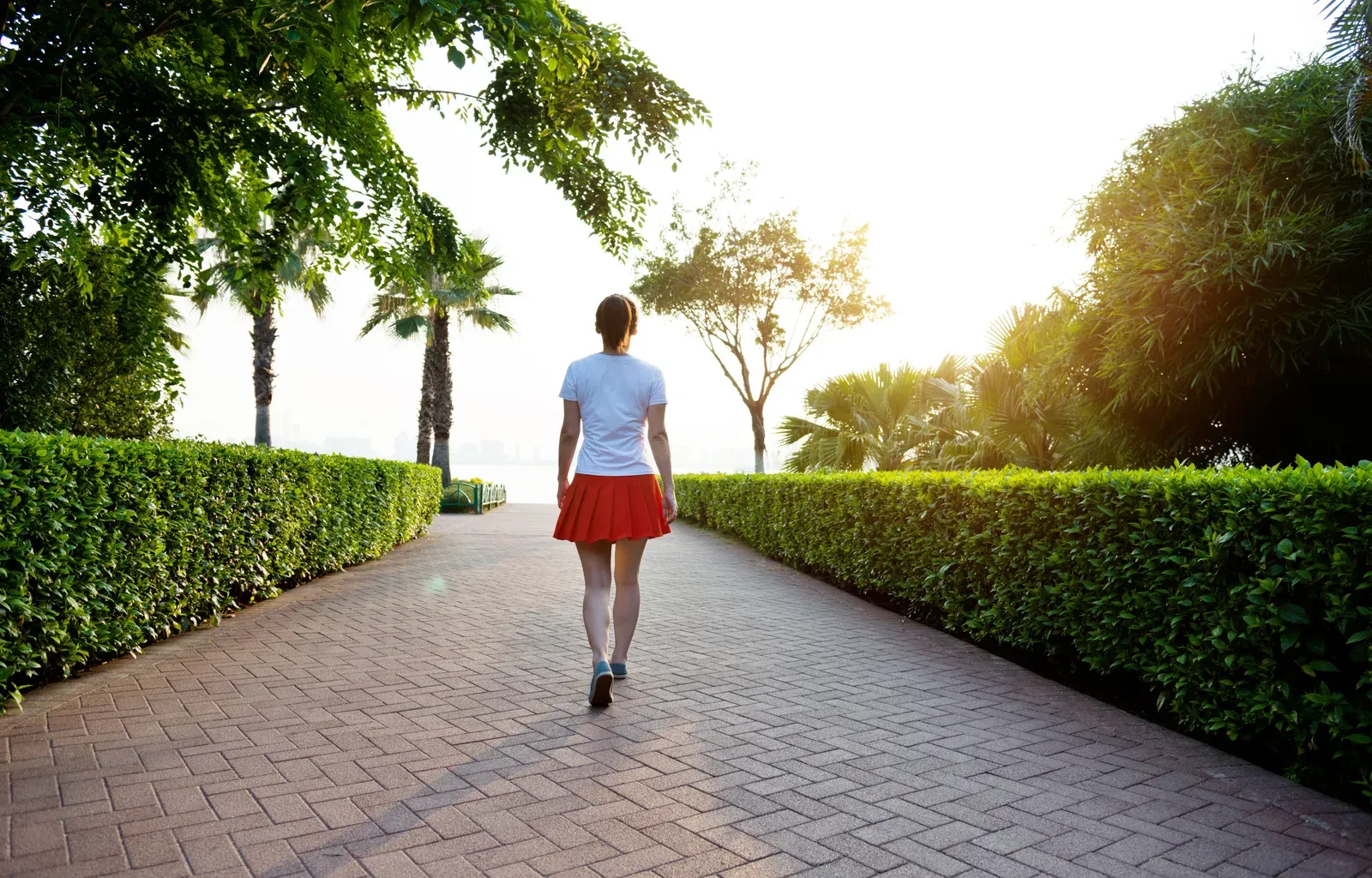 Woman walking along a brick footpath, an easy first step toward fitness