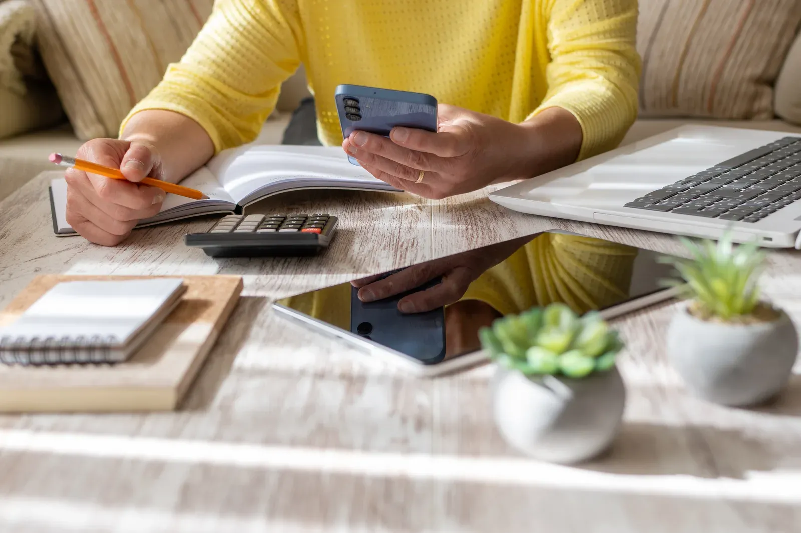 A notebook, pencil, and calculator laid out to plan a short block of training sessions