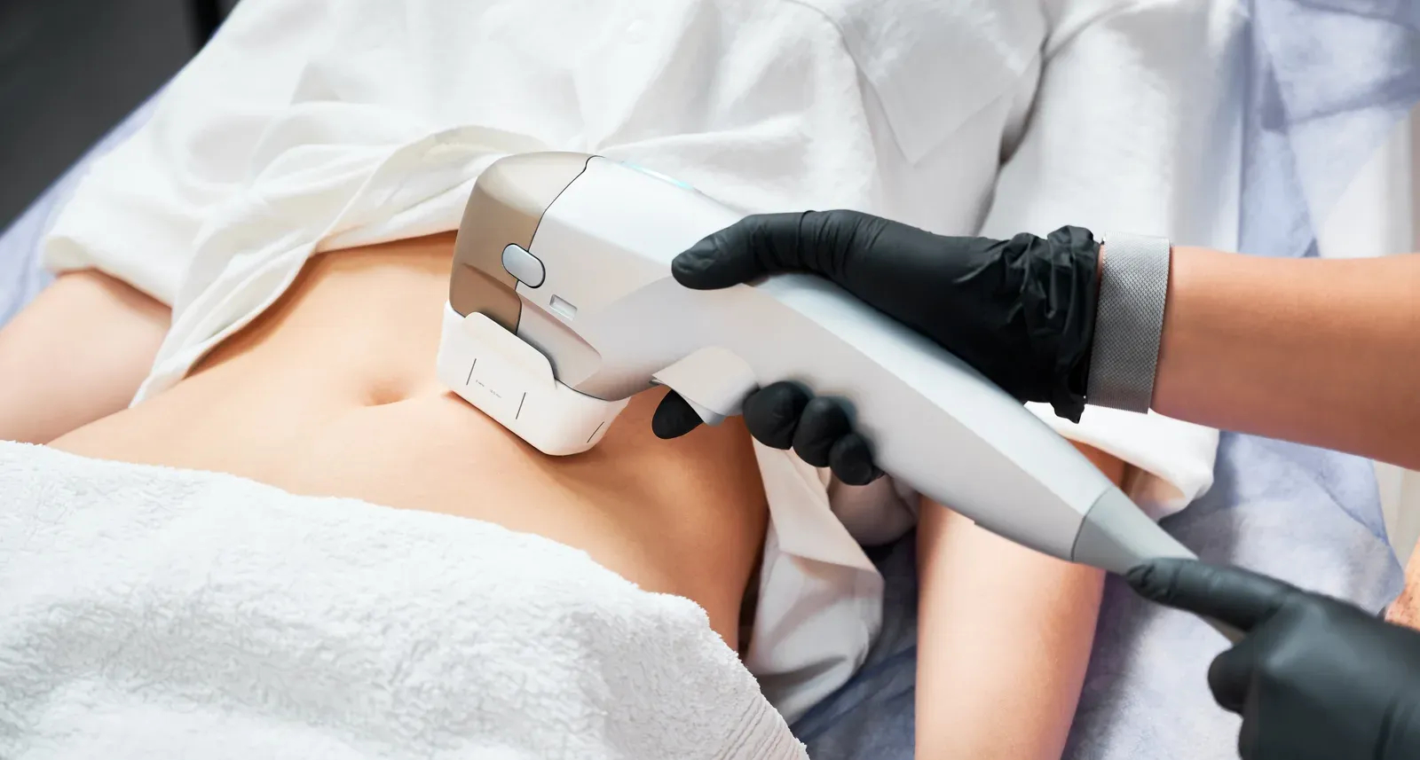 Clinician assessing a woman's midsection during an appointment at a clinic