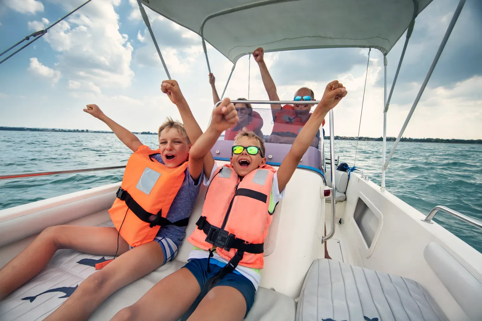 A family riding a boat across a lake on a summer day