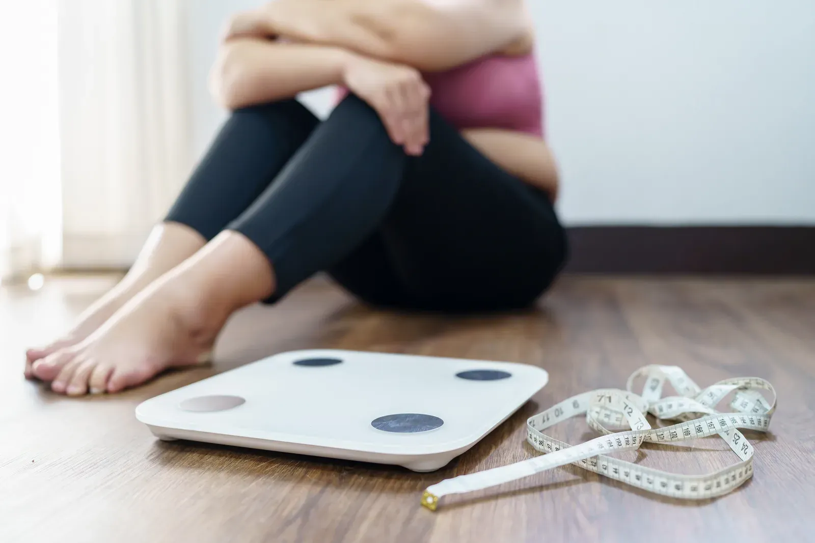 Frustrated woman checking the number on her home bathroom scale