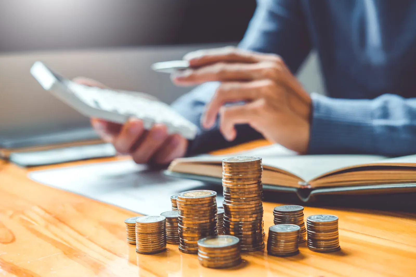 Stacking coins in rows while budgeting for monthly personal training costs