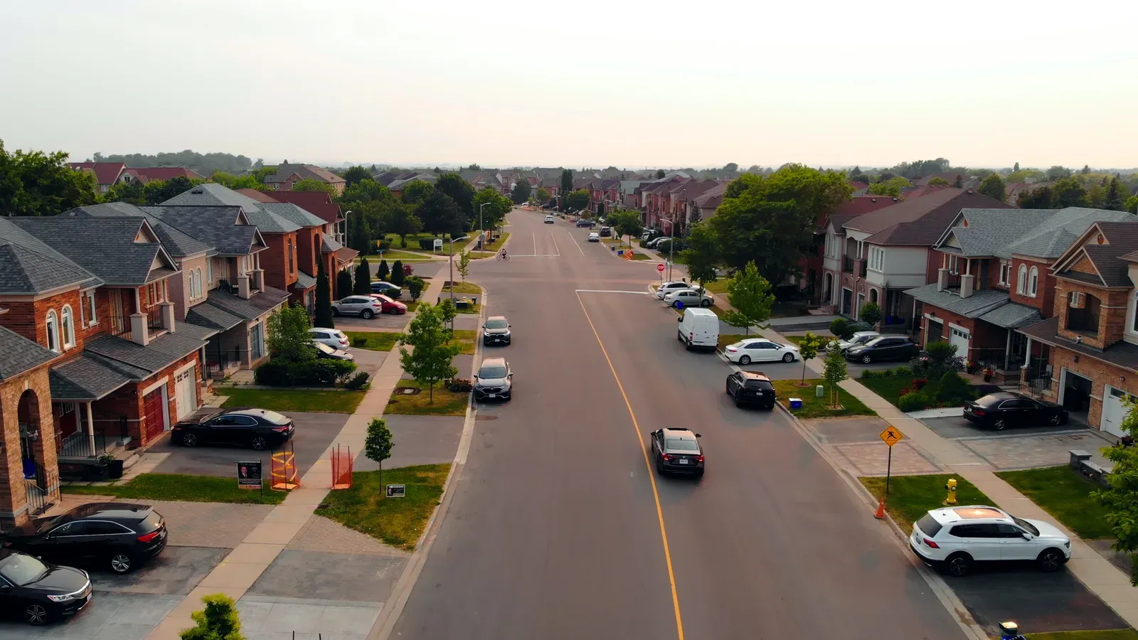 Wide residential street running through a newer subdivision of two story homes