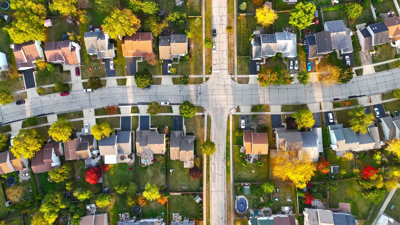 Top down view of a neighborhood crossroads ringed by early autumn color