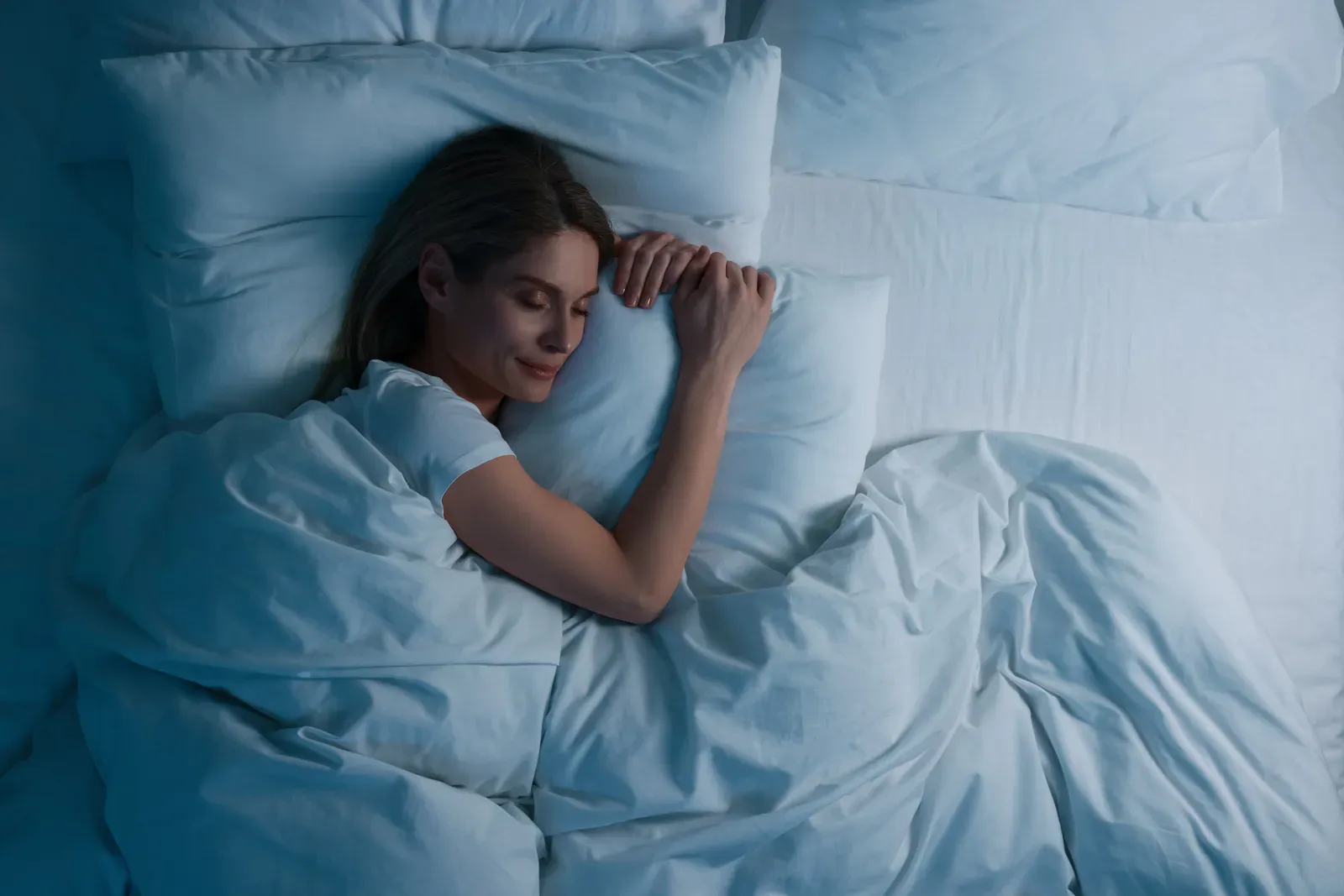 Woman sound asleep in bed at night, recovery that supports training results