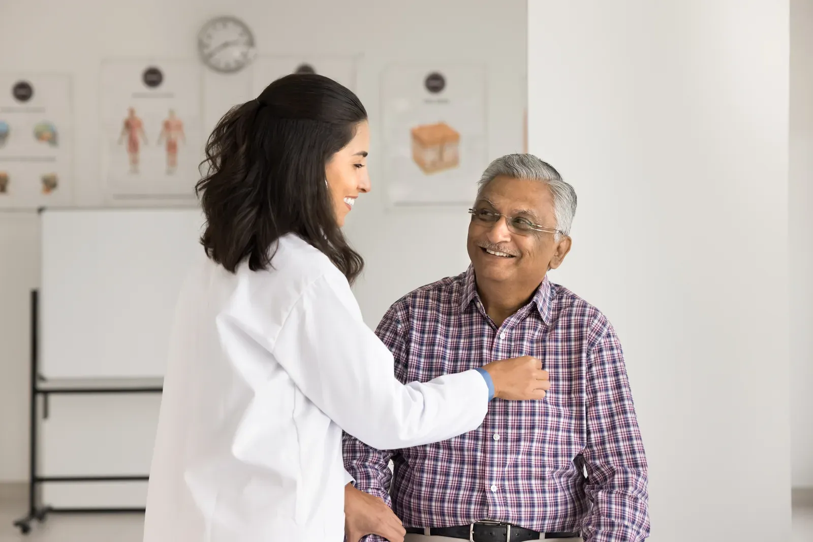 A cardiologist listening to an older patient's heartbeat with a stethoscope