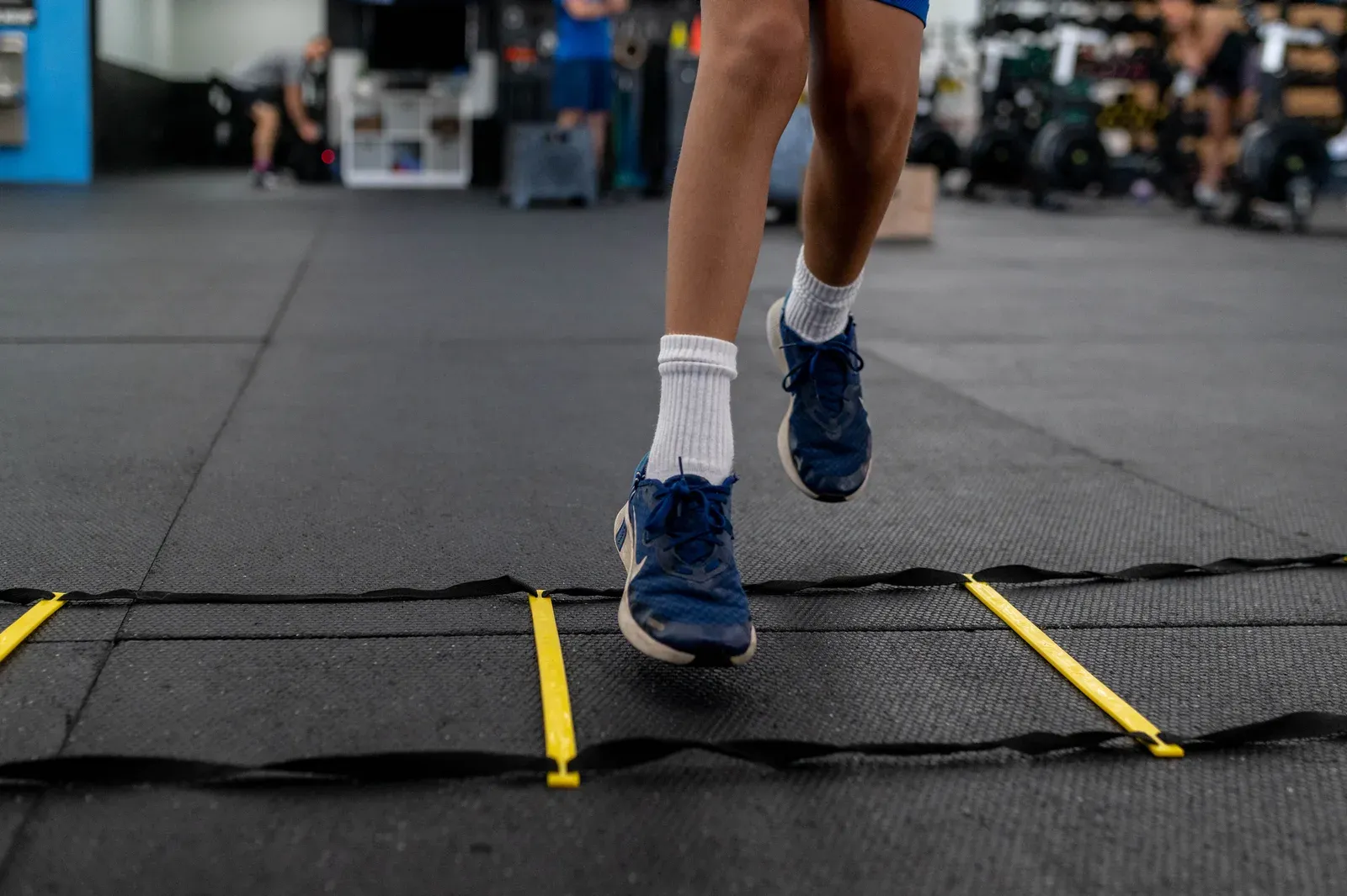 Young athlete driving out of a sprint start during a speed training session