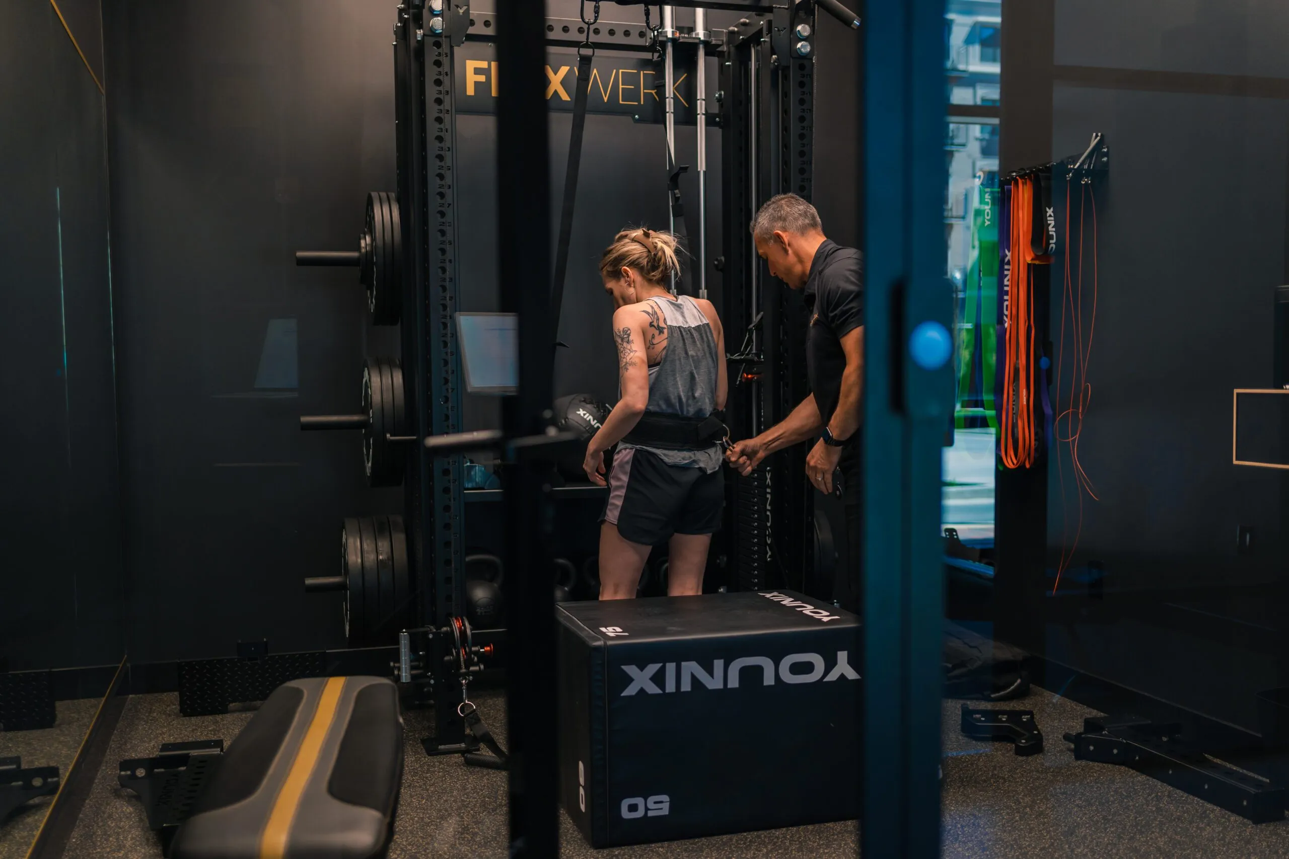 A coach working with a client at a rack inside a private FlexWerk space