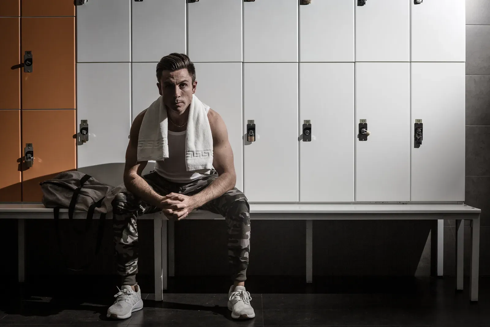 Strong athlete winding down with a towel in the changing room