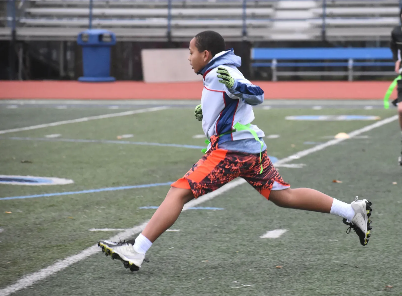 Young flag football players running down the field during a game
